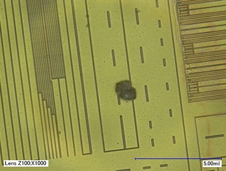 In einen IC-Chip eingebundenes Fremdpartikel (1000x)